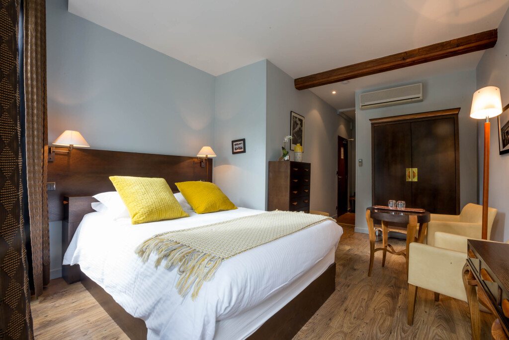 Chambre climatisée aux murs bleu pâle, lit blanc et accents jaune