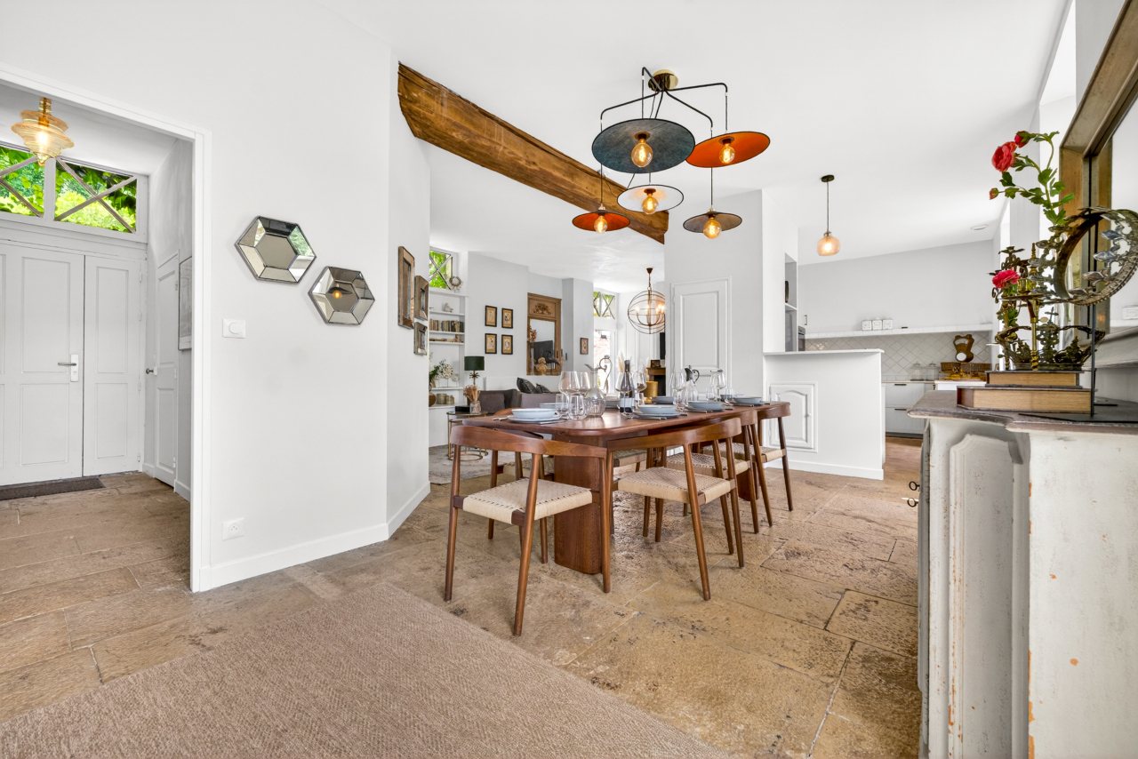 Salle à manger ouverte sur cuisine et salon, poutre apparente